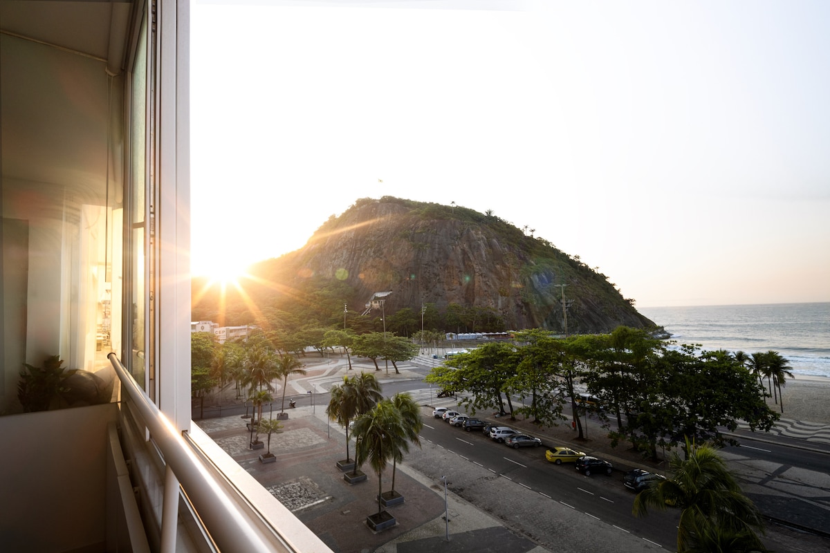 Sala de estar com vista para o mar do Leme ao entardecer