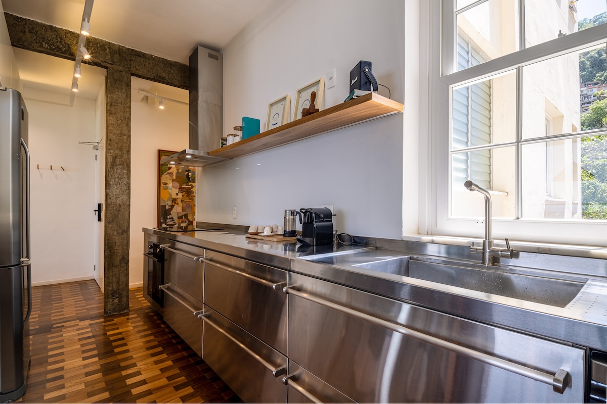 Prateleira da cozinha com quadros, livros e Nespresso