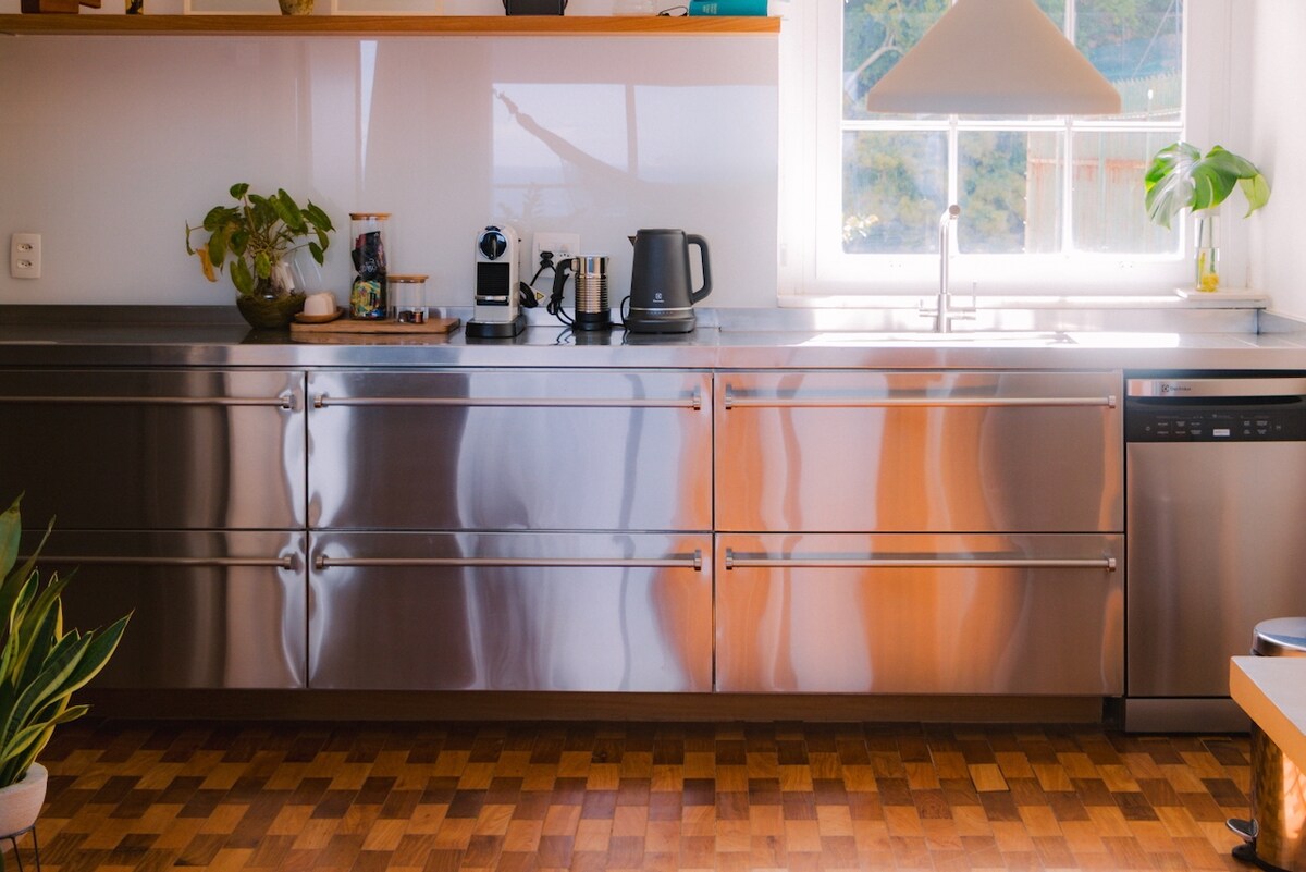 Cozinha de inox com janela para a mata