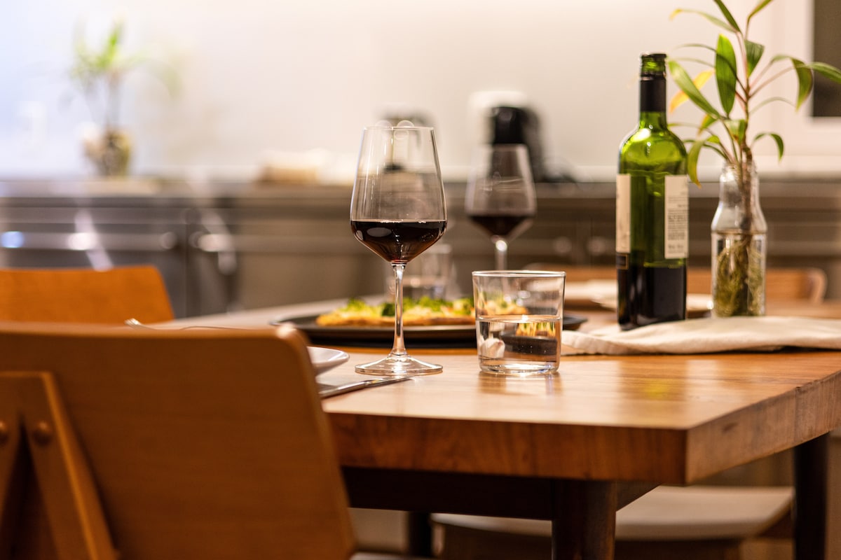 Prato servido e taça de vinho tinto na mesa de madeira