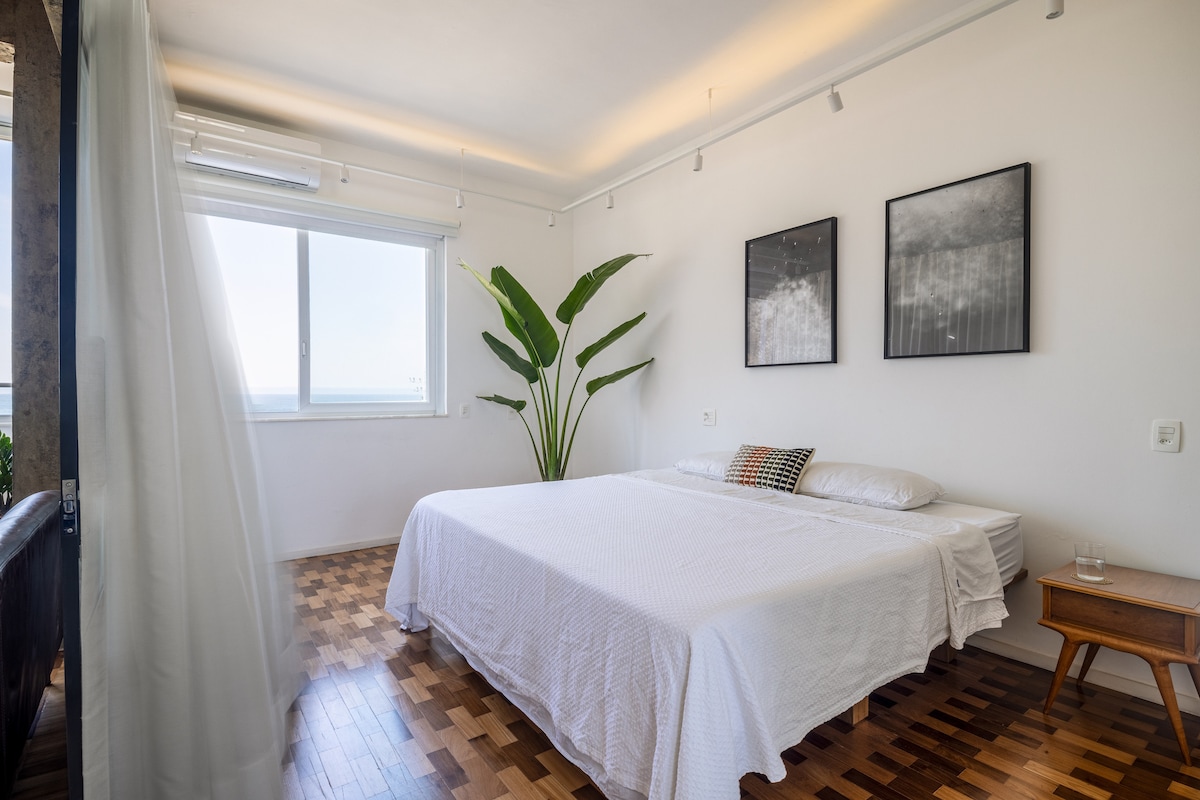 Quarto com cama king e porta de correr de vidro para a sala