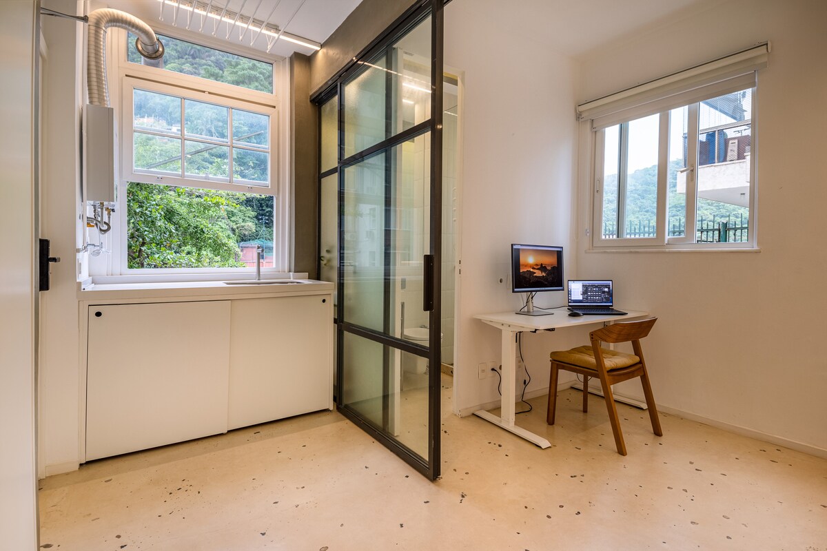Escritório separado com porta de vidro e vista para a mata